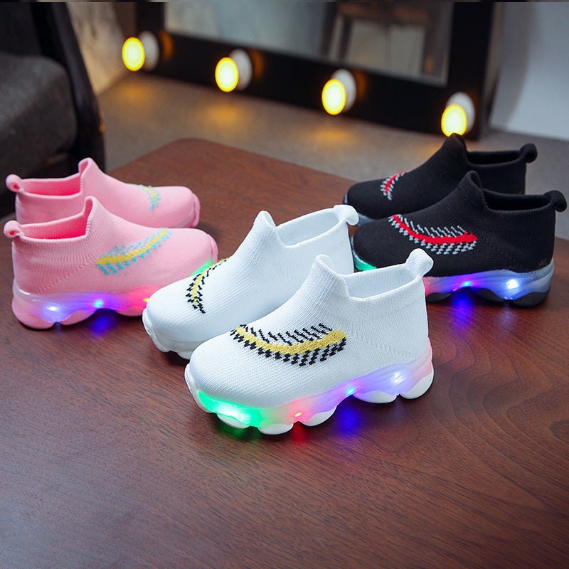 Colorful LED shoes on a wooden surface with blurred lights in the background