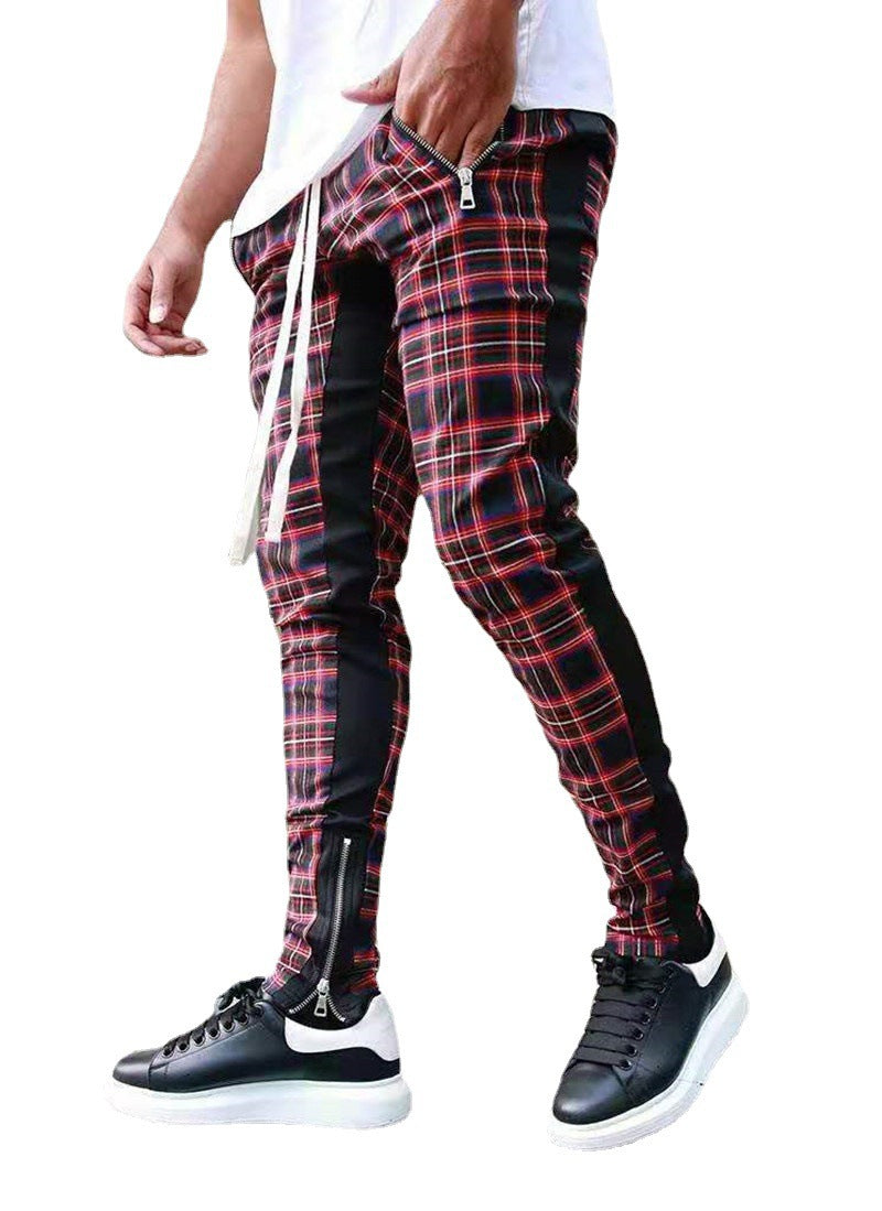 Red and black plaid pants with zippers worn by a person on a white background