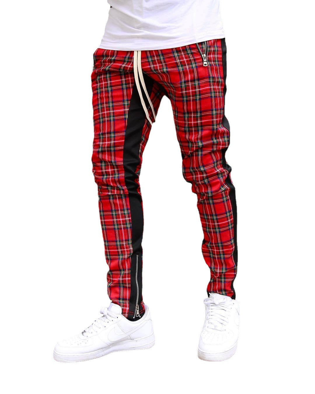 Red plaid pants with black side panels worn by a person on a white background