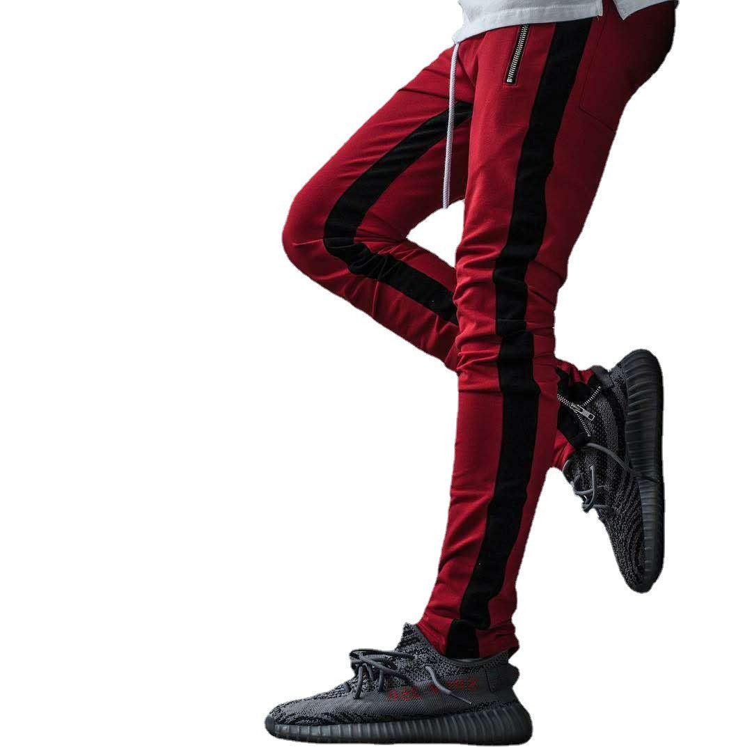 Red and black striped pants with black sneakers on a white background