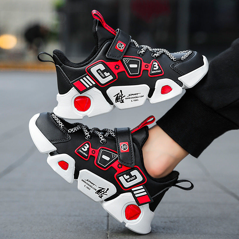 Black, red, and white sneakers with chain details on a blurred street background