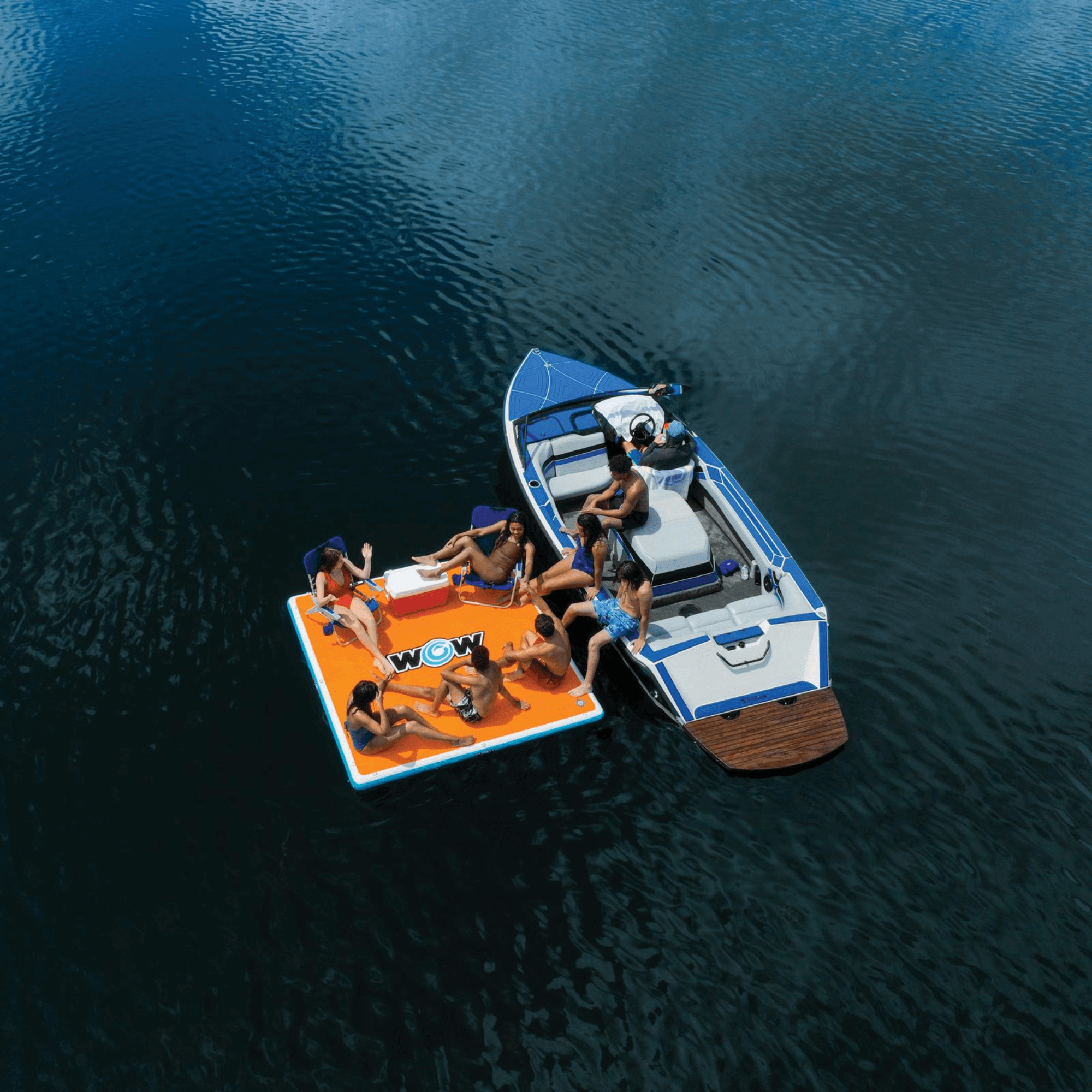 People lounging on a boat and inflatable raft on a body of water