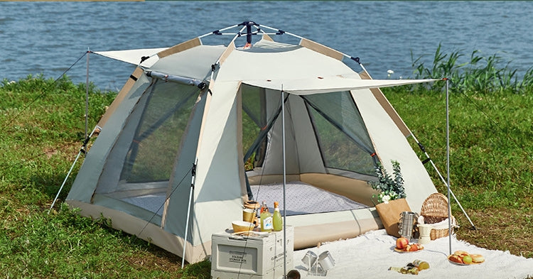 Camping tent with outdoor furniture and food near a body of water
