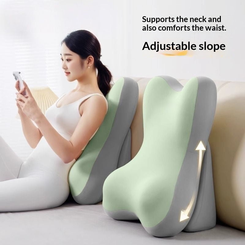 A woman sits on a sofa using a light green and gray ergonomic lumbar pillow to support her neck and waist, with text reading 'Supports the neck and also comforts the waist. Adjustable slope' on a light background.