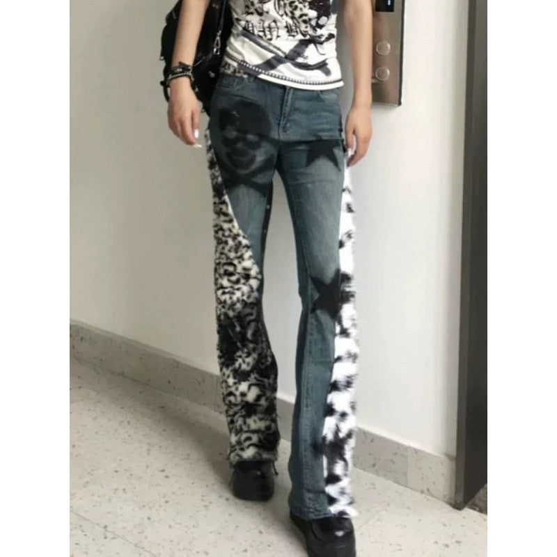 Person wearing blue jeans with tie-dye accents in a minimal indoor setting