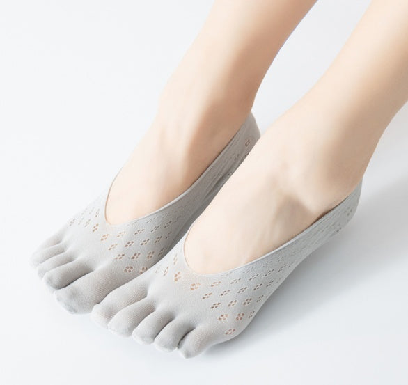 Gray toe-separated socks worn by a person on a light gray background