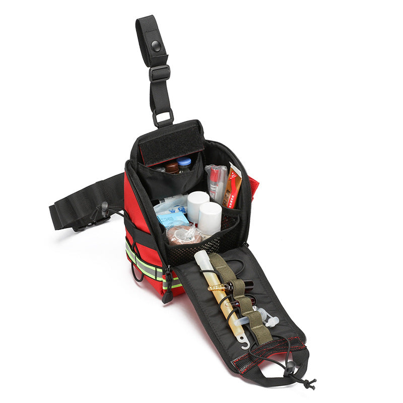An open red and black emergency first aid kit pouch with various medical supplies and tools arranged inside, shown on a clean white background.