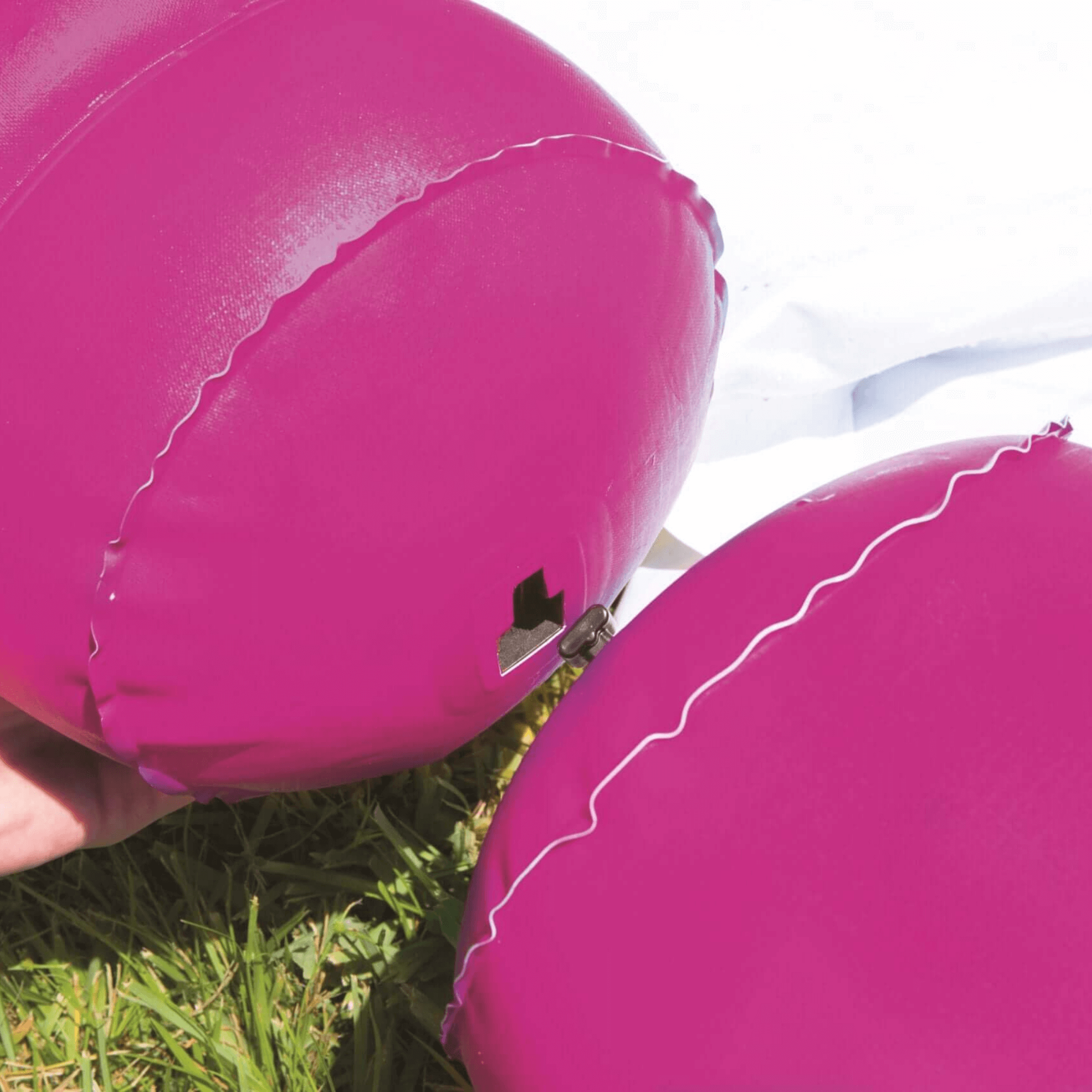 Close-up of a pink inflatable on a visible crack on grass