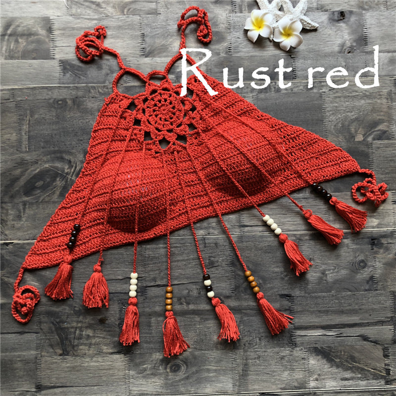 Red crochet top with tassels on a wooden surface, labeled 'Rust red'.