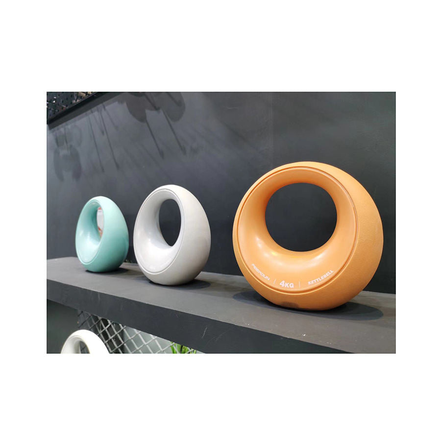 Three circular objects in different colors on a reflective surface with a dark background