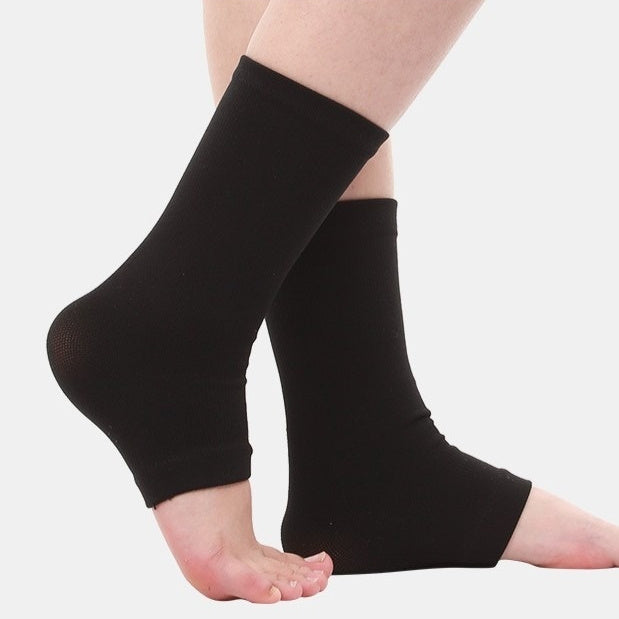 Black compression ankle sleeves worn on both legs, shown against a plain light gray background.
