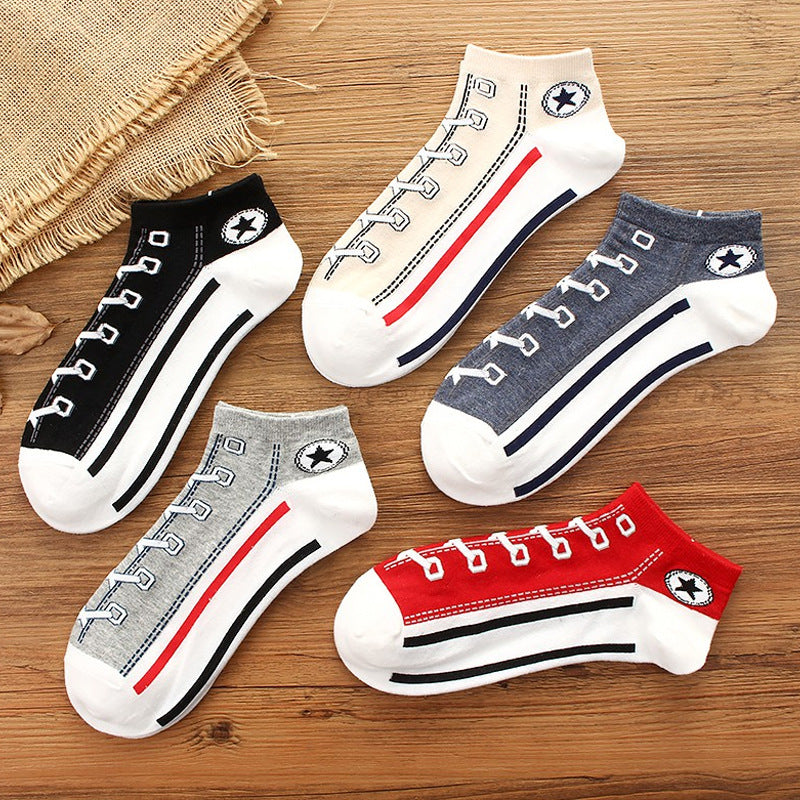 Set of five pairs of socks with shoe lace design on a wooden surface