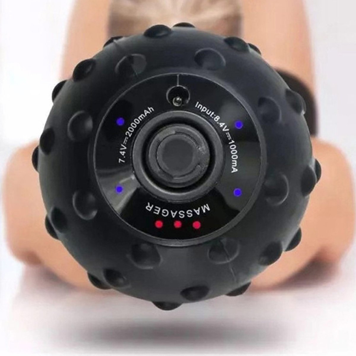 Black massage ball with battery indicators held by a person on a white background