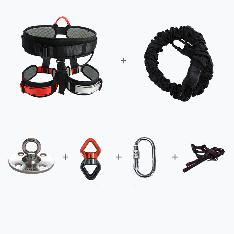 A product bundle containing a black and red climbing harness, a black quick-release lanyard, a silver metal anchor plate, a red and black belting device, a silver carabiner, and a dark brown climbing rope, all arranged on a clean white background with plus signs indicating a multi-piece set.