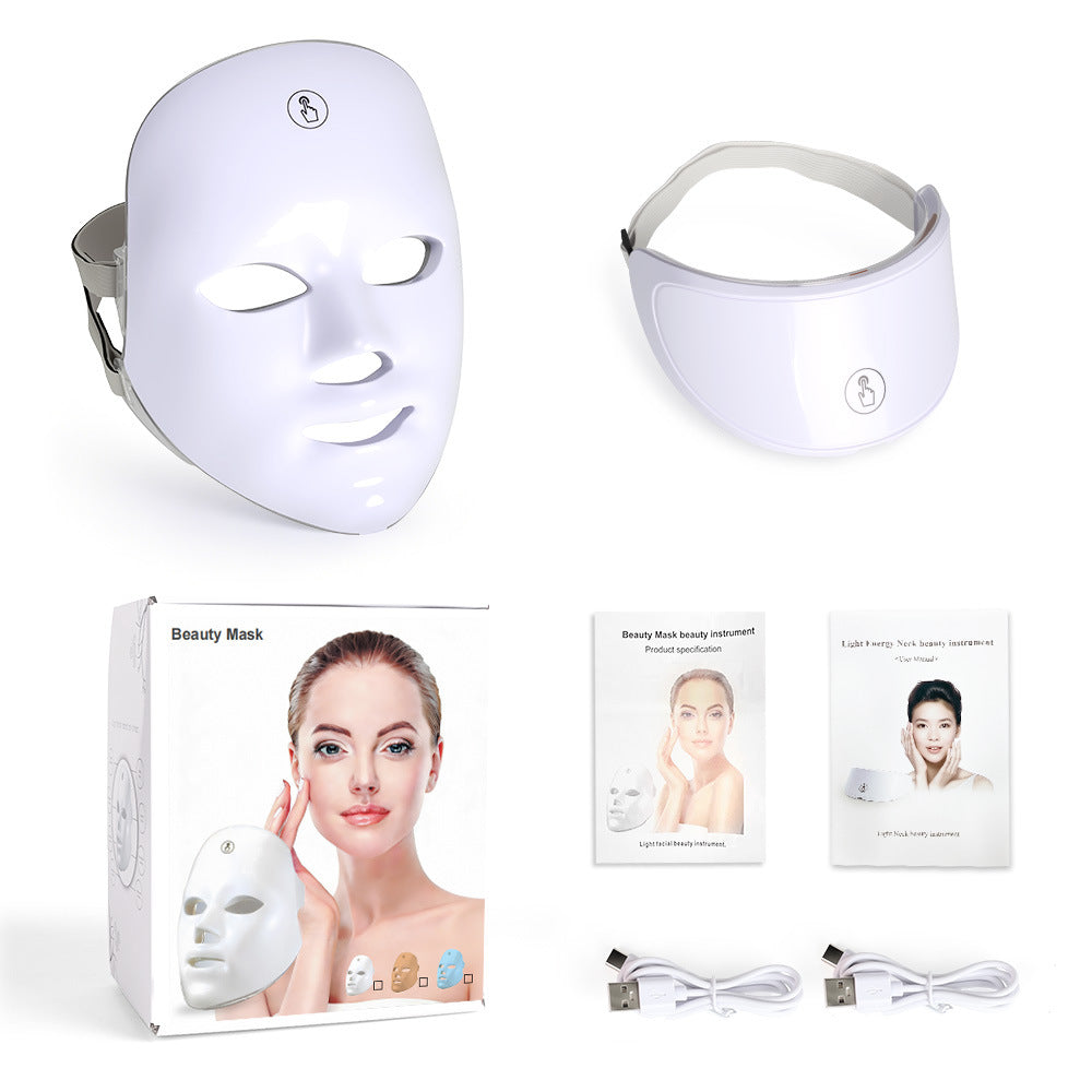White LED beauty mask set with a contoured face mask, a headband-style mask, its retail box, user manuals, and two USB charging cables on a plain white background.
