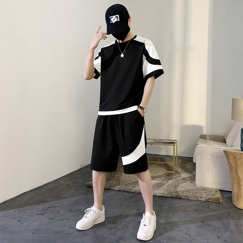 Person wearing a black and white outfit with a cap in an indoor setting