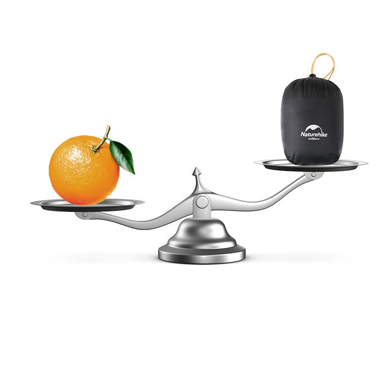 Scale with an orange on one side and a black Naturehike bag on the other, on a white background