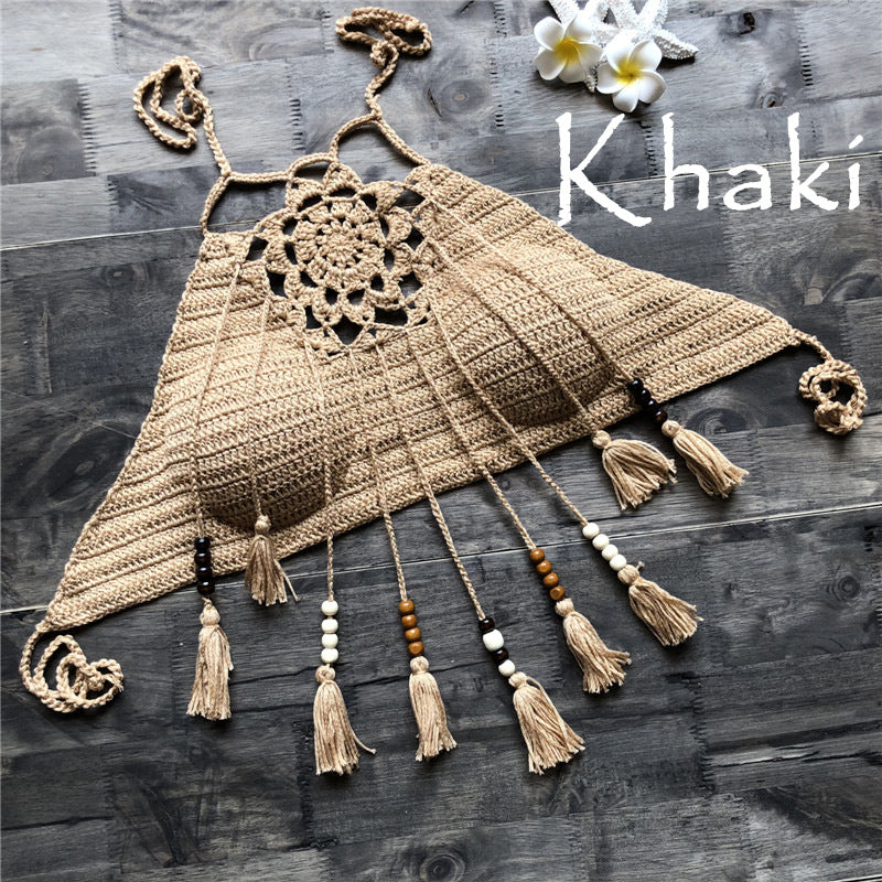 Khaki-colored crochet top with tassels on a wooden surface, featuring the brand 'Khaki'.