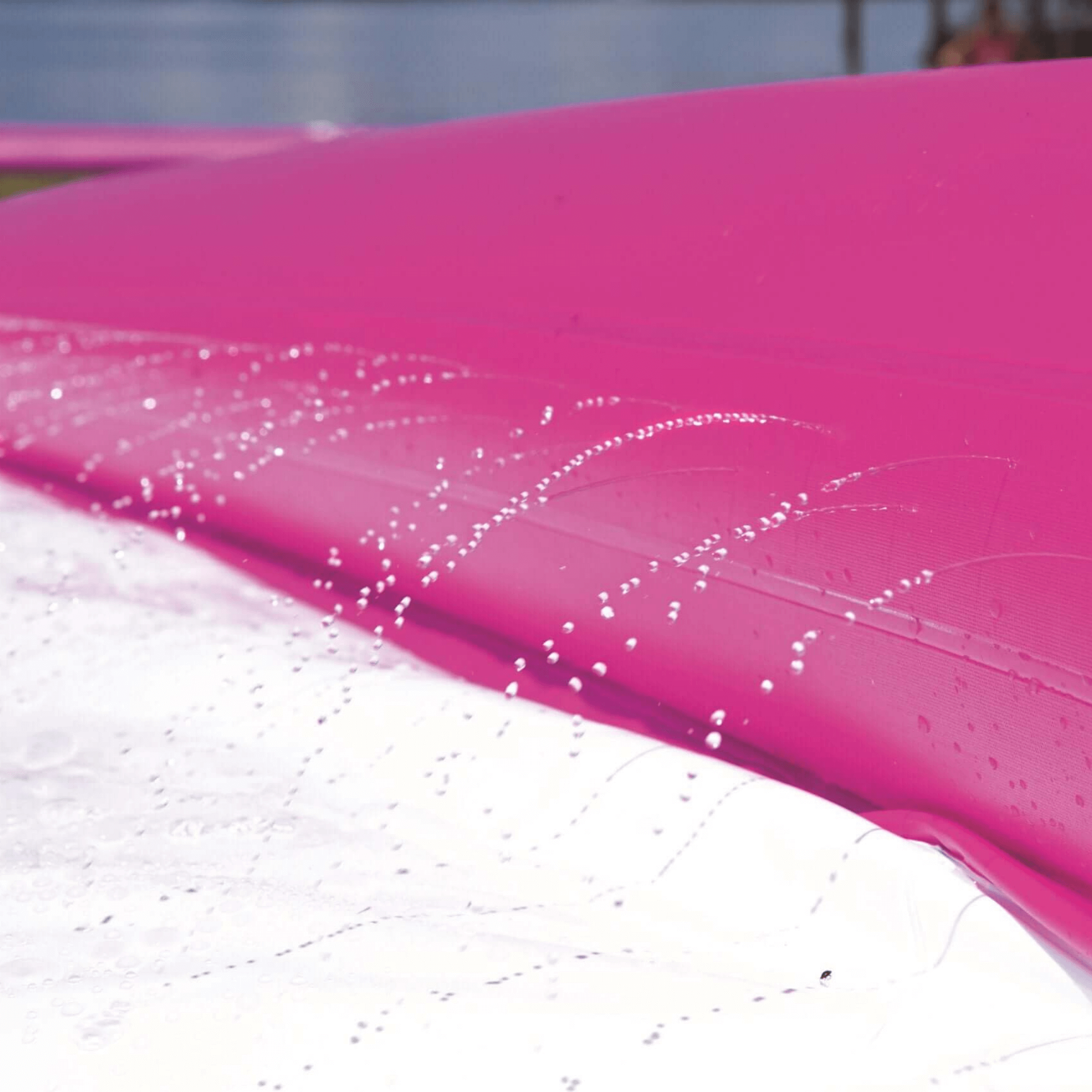 Close-up of a pink pool with water splashes and a blurred background