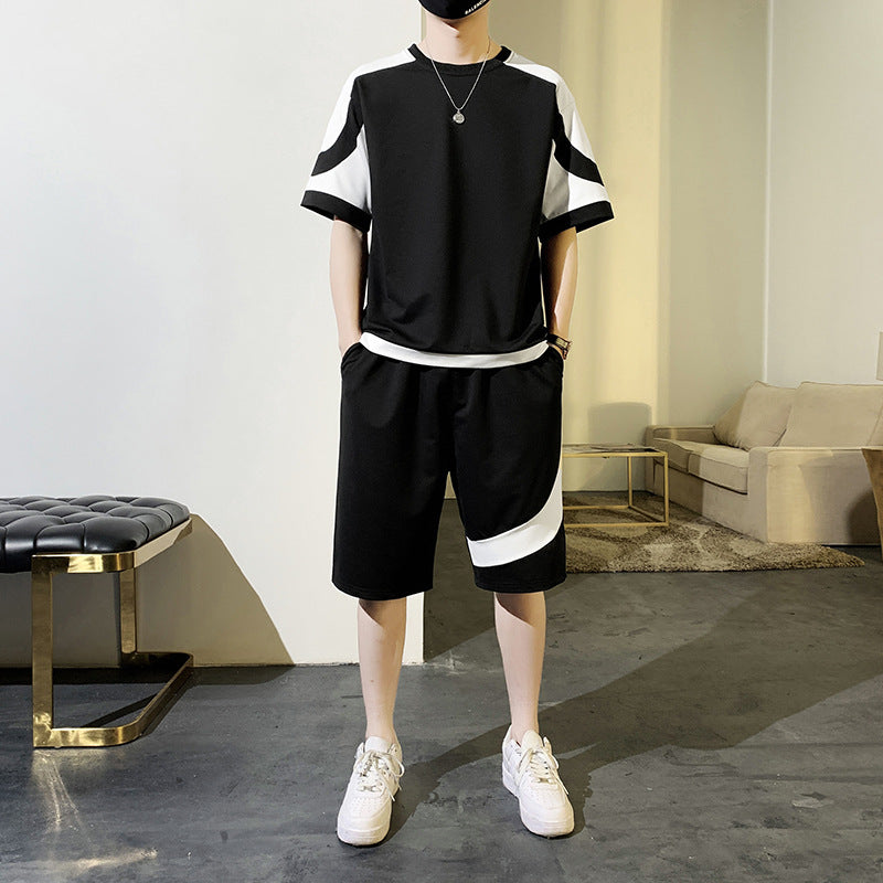 Person wearing a black and white outfit in a modern room.