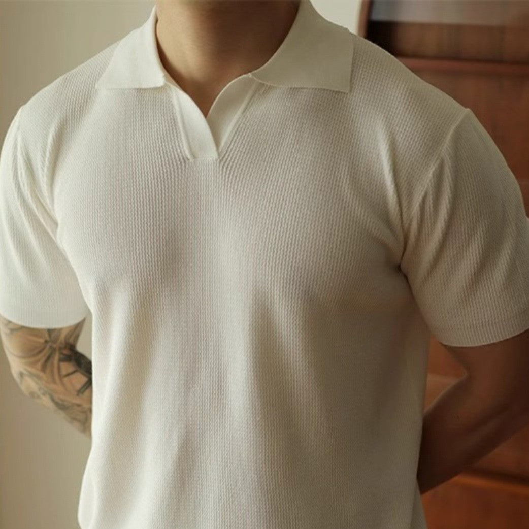 Person wearing a beige short-sleeve shirt with a blurred background
