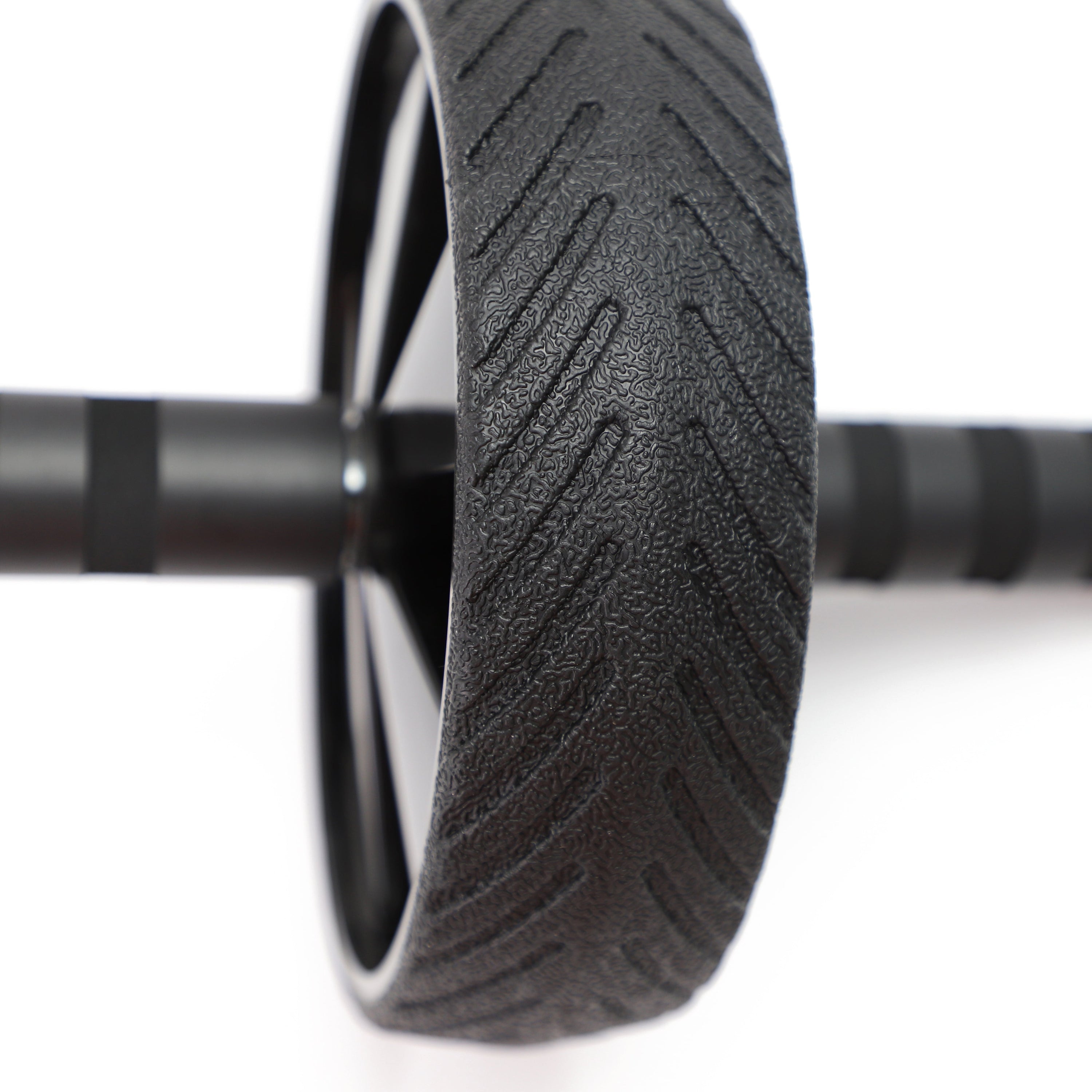 Close-up of a black wheel with tread pattern on a white background