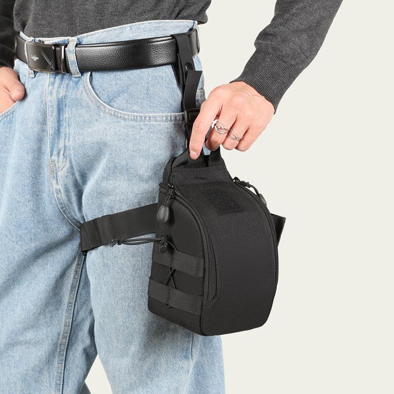A black tactical hip pouch with a quick-release buckle strap, worn on the hip of a model wearing light blue jeans and a black belt, against a light gray background.