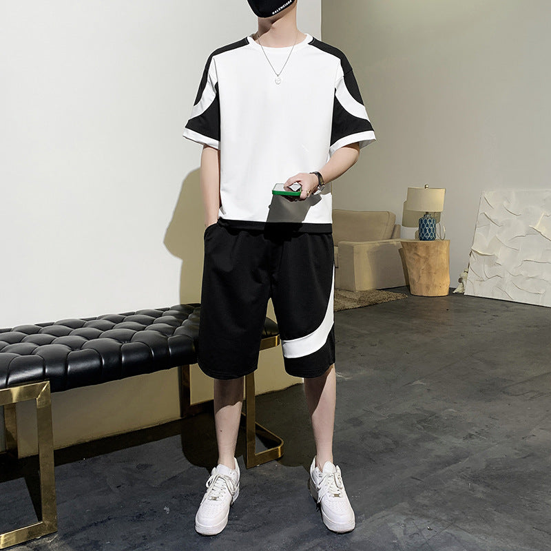 Person wearing a black and white outfit in a room with furniture.
