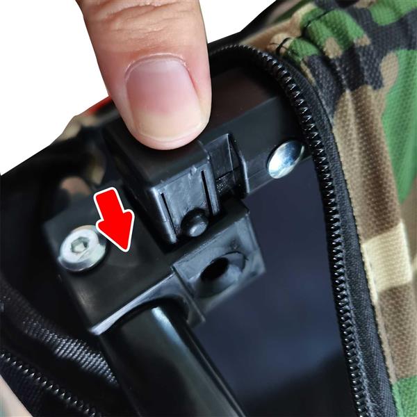 Close-up of a person's hand holding a black device with a red arrow pointing to a small component.