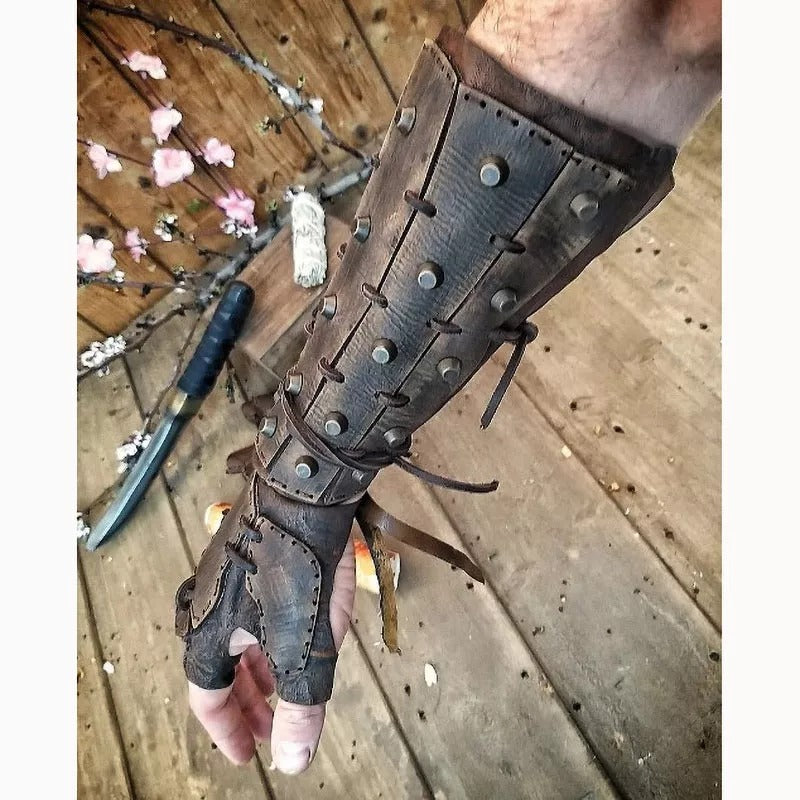 Leather arm guard with metal studs on a wooden floor