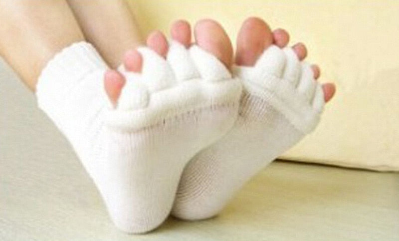 White toe separators worn by a person on a light background