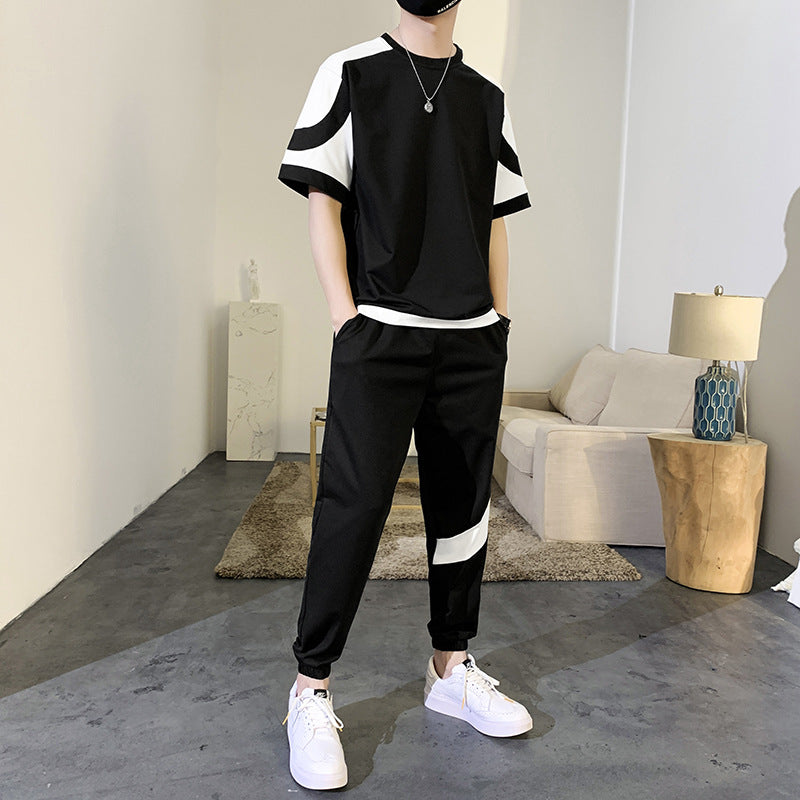 Person wearing a black and white outfit in a modern living room.