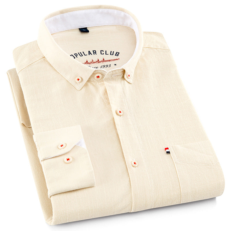 Folded beige shirt with white collar and 'Opular Club' branding on a white background