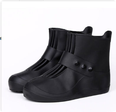 Black rubber rain boots with buttons on a white background