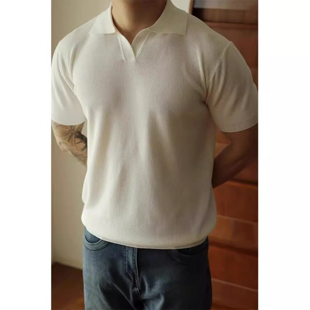 Person wearing a white polo shirt and blue jeans indoors.