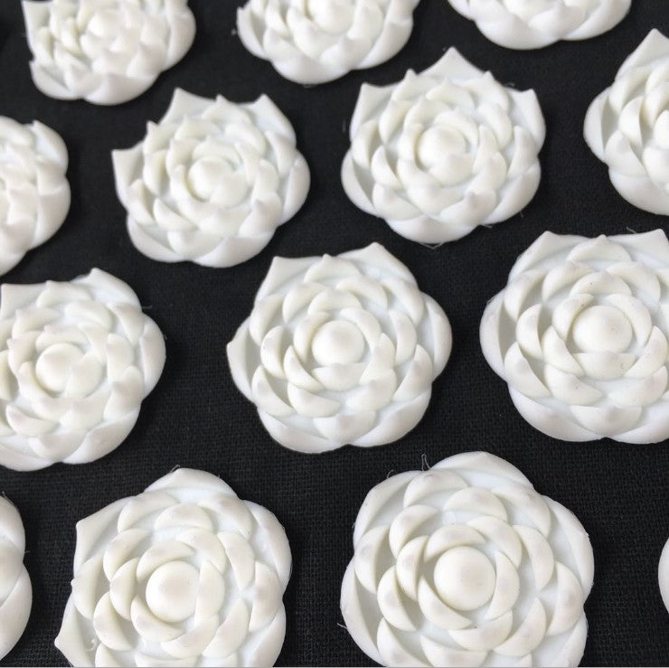 White floral-shaped objects on a black background