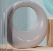 Round gray object on a shelf with a light blue wall in the background