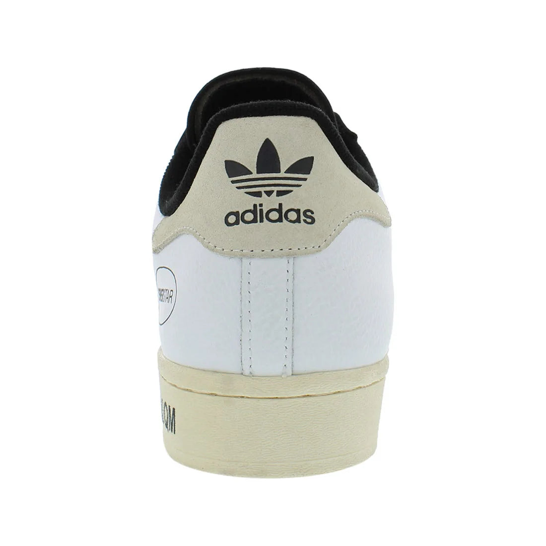 Adidas sneaker with a white sole and beige heel tab on a white background