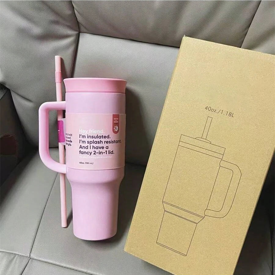 Pink 40 oz travel tumbler with matching handle and lid, straw alongside, beside a cardboard product box.