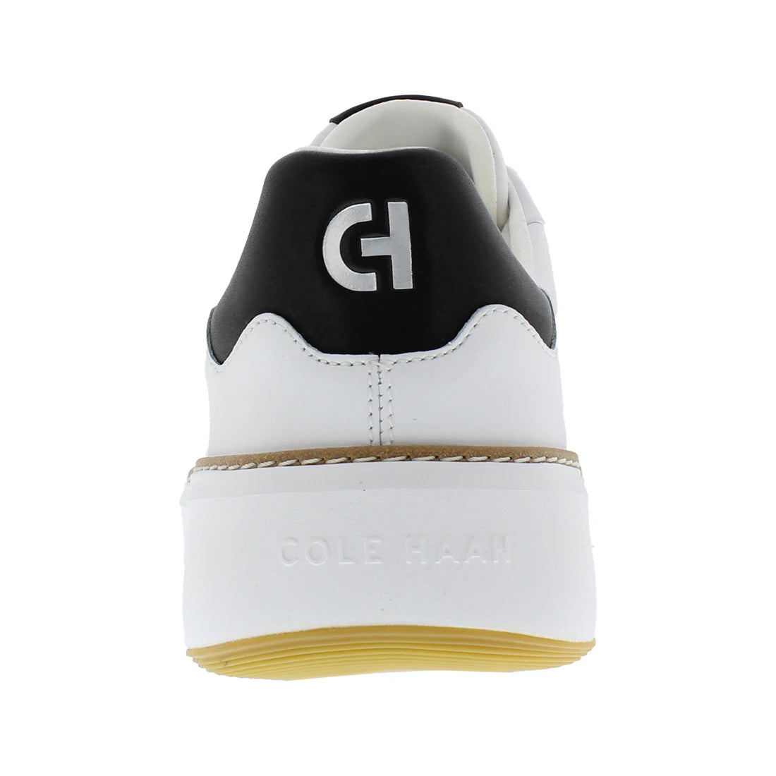A rear view of a white leather sneaker by Cole Haan, featuring a black heel tab with a white 'CH' logo, a white midsole with embossed branding, and a yellow gum outsole.