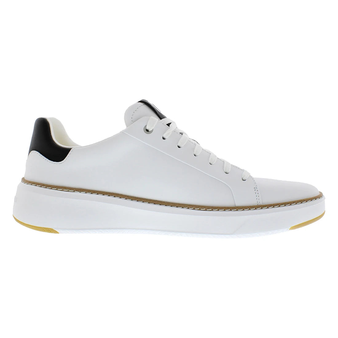 A white leather low-top sneaker with a chunky white sole, a thin tan stitching line, a black heel tab, and a small gold accent on the outsole.