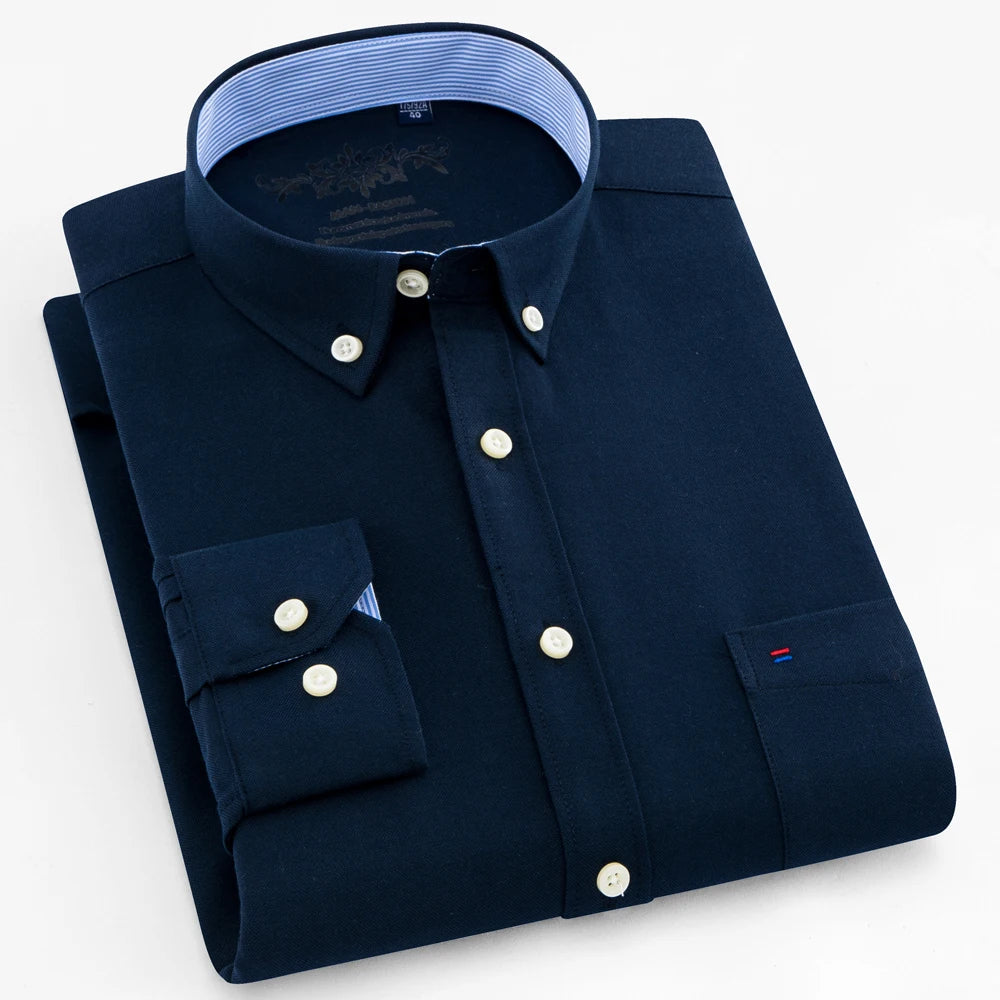 Folded navy blue shirt with white buttons on a light gray background