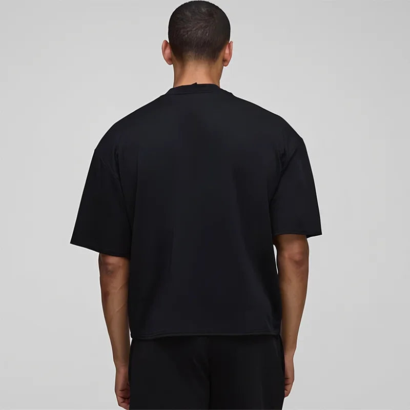 Person wearing a black t-shirt on a plain background