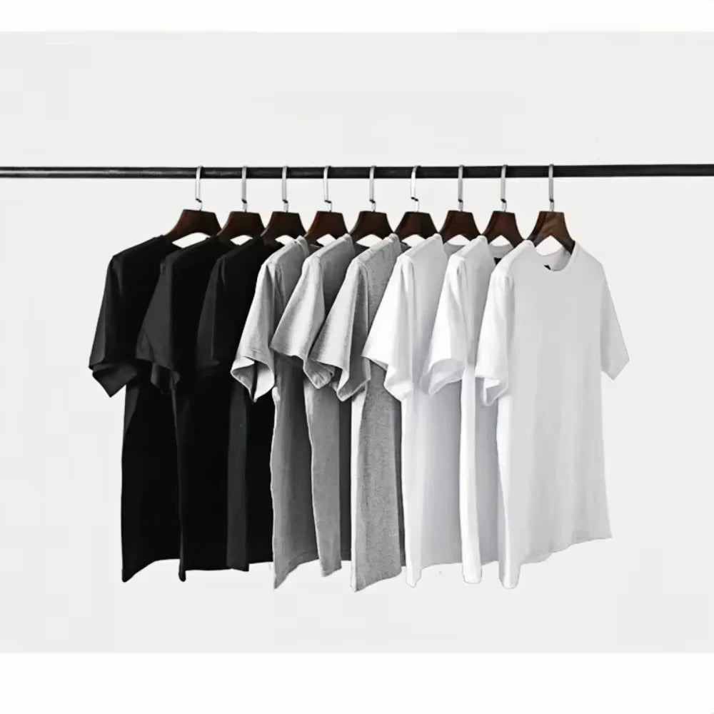 Row of black, gray, and white t-shirts on hangers against a white background