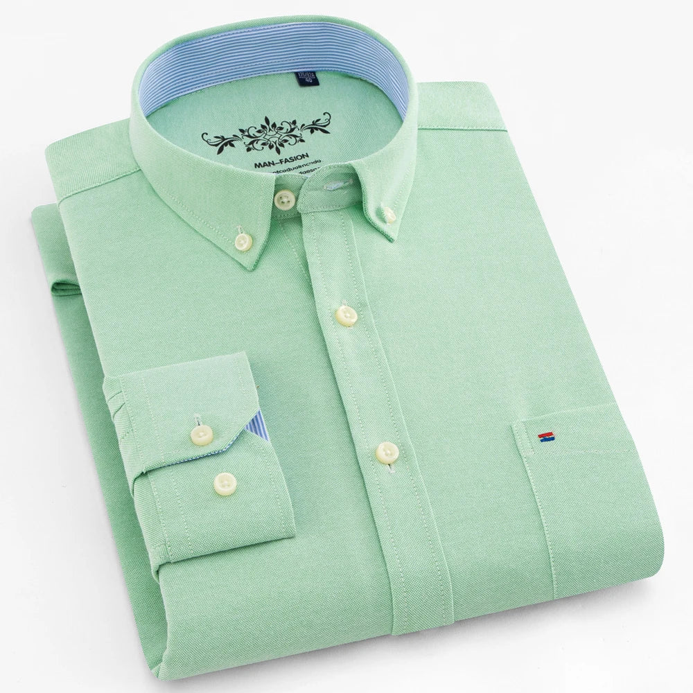 Folded light green shirt with a blue collar on a white background