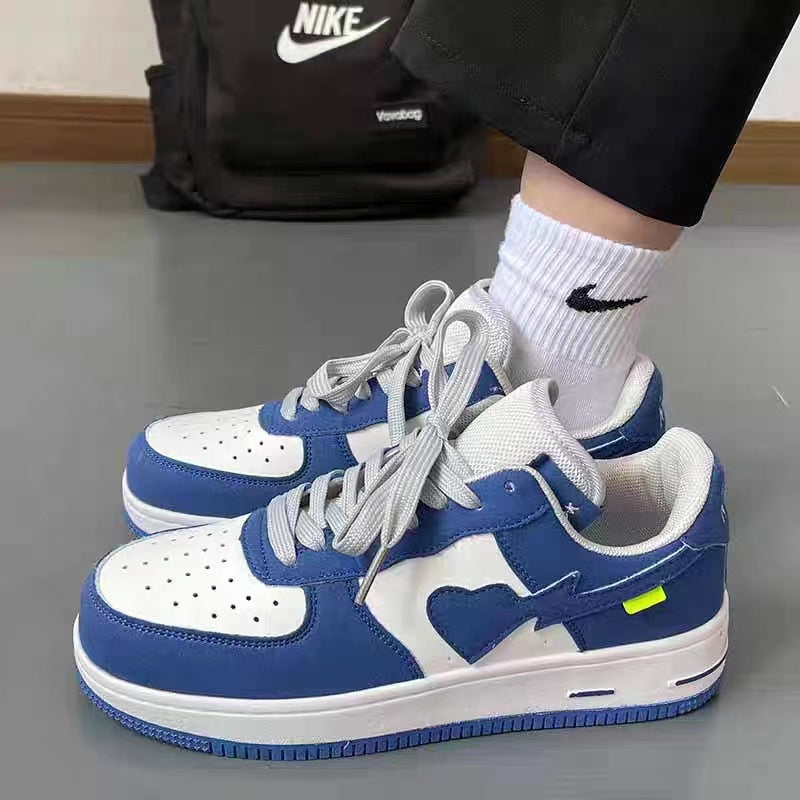 Blue and white sneakers with a heart design worn by a person, with a Nike backpack in the background.