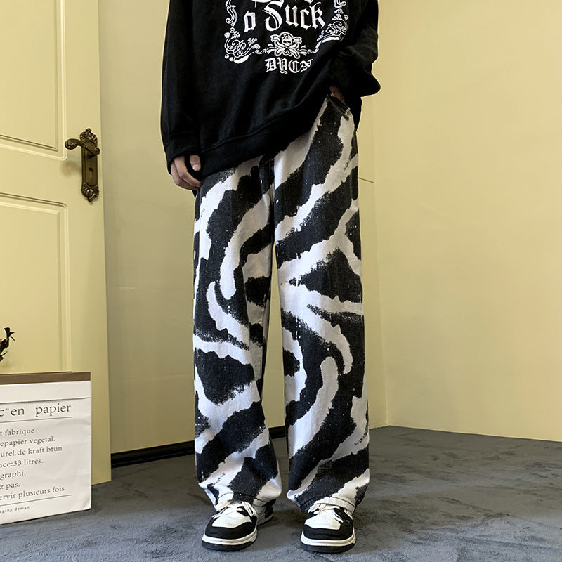 Person wearing a black and white zebra print outfit with a black sweatshirt and pants in a room.