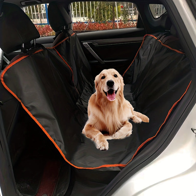 Dog sitting on a black car seat cover with orange trim in a vehicle.