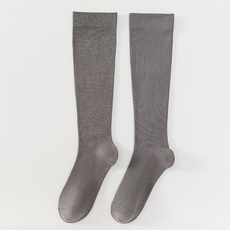 A pair of heather gray over-the-knee socks laid flat on a light gray background.