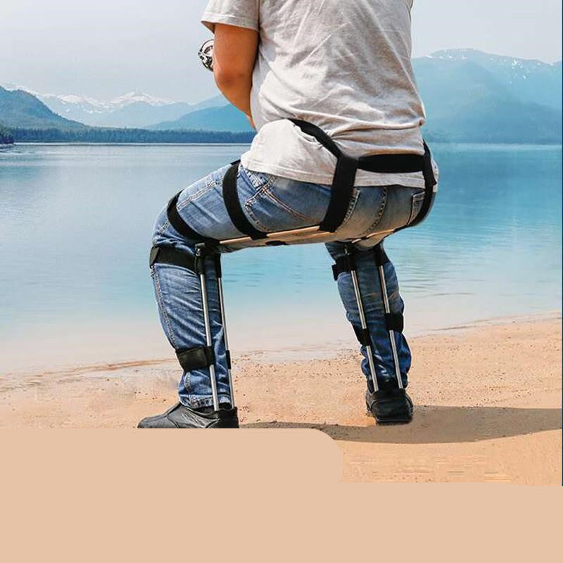 Person using a mobility aid on a beach with mountains in the background
